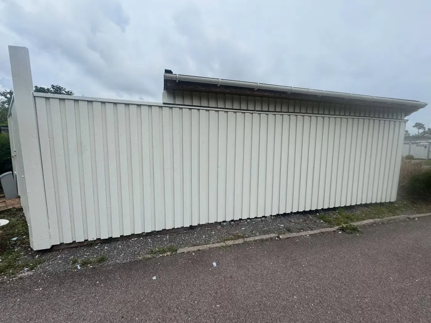 Vit träfasad på ett uthus i gott skick efter målning
