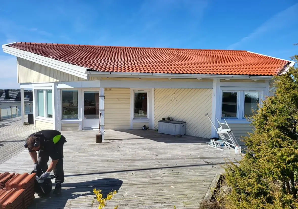 Des couvreurs posent de nouvelles tuiles rouges sur une maison